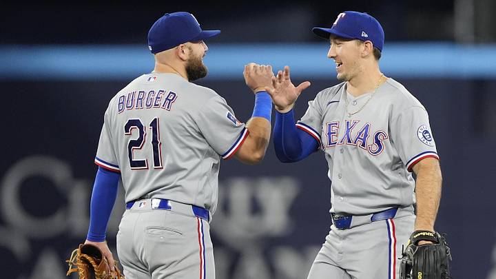 Jun 25, 2026; Toronto, Ontario, CAN; Texas Rangers center fielder Wyatt Langford (36) and first baseman Jake Burger (21) celebrate a win over the Toronto Blue Jays at Rogers Centre. Mandatory Credit: John E. Sokolowski-Imagn Images