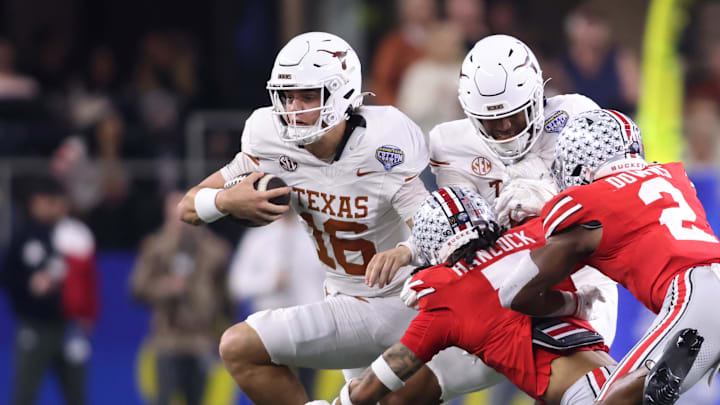 Jan 10, 2025; Arlington, Texas, USA; Texas Longhorns quarterback Arch Manning (16) runs against Ohio State Buckeyes cornerback Jordan Hancock (7) and safety Caleb Downs (2) during the second quarter of the College Football Playoff semifinal in the Cotton Bowl at AT&T Stadium. Mandatory Credit: Tim Heitman-Imagn Images