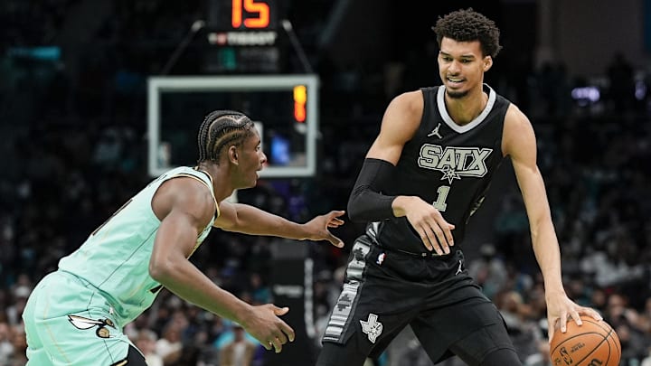 Feb 7, 2025; Charlotte, North Carolina, USA;  San Antonio Spurs center Victor Wembanyama (1) handles the ball against Charlotte Hornets forward Moussa Diabate (14) during the second half at Spectrum Center. Mandatory Credit: Jim Dedmon-Imagn Images