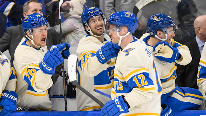 Feb 8, 2025; St. Louis, Missouri, USA;  St. Louis Blues center Radek Faksa (12) is congratulated by center Zack Bolduc (76) and center Jordan Kyrou (25) after scoring the game winning goal in the 10th round of shootouts against the Chicago Blackhawks at Enterprise Center. Mandatory Credit: Jeff Curry-Imagn Images