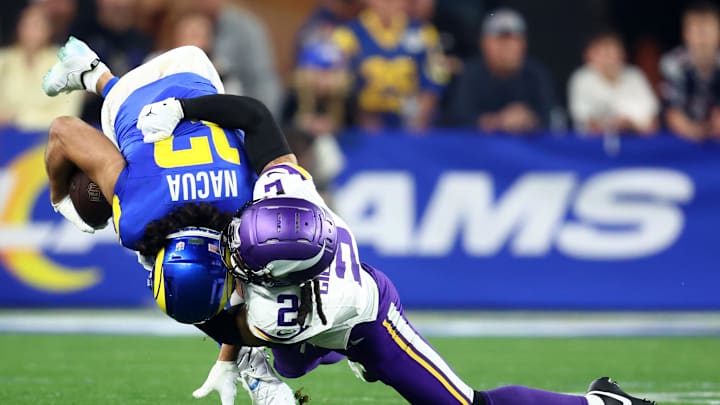 Jan 13, 2025; Glendale, AZ, USA; Los Angeles Rams wide receiver Puka Nacua (17) makes a catch against Minnesota Vikings cornerback Stephon Gilmore (2) during the second half in an NFC wild card game at State Farm Stadium. Mandatory Credit: Mark J. Rebilas-Imagn Images