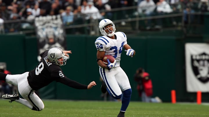 Dec 16, 2007; Oakland, CA, USA; Indianapolis Colts safety TJ Rushing (34) avoids the tackle of Oakland Raiders punter Shane Lechler (9) while returning a punt for a touchdown during the first quarter at McAfee Coliseum in Oakland, CA. Mandatory Credit: Phil Carter-Imagn Images