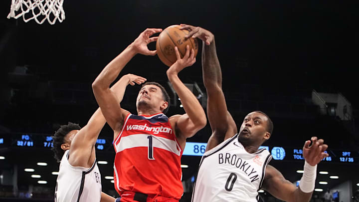 Oct 14, 2024; Brooklyn, New York, USA; Brooklyn Nets forward Dariq Whitehead (0) blocks a shot attempt by Washington Wizards guard Johnny Davis (1) during the second half at Barclays Center. Mandatory Credit: Gregory Fisher-Imagn Images