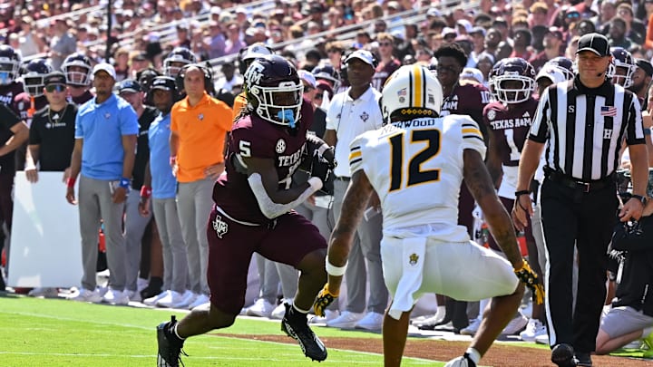 Oct 5, 2024; College Station, Texas, USA;  Texas A&M Aggies running back Amari Daniels (5) runs the ball for a touchdown in the first quarter against the Missouri Tigers at Kyle Field. Mandatory Credit: Maria Lysaker-Imagn Images. 