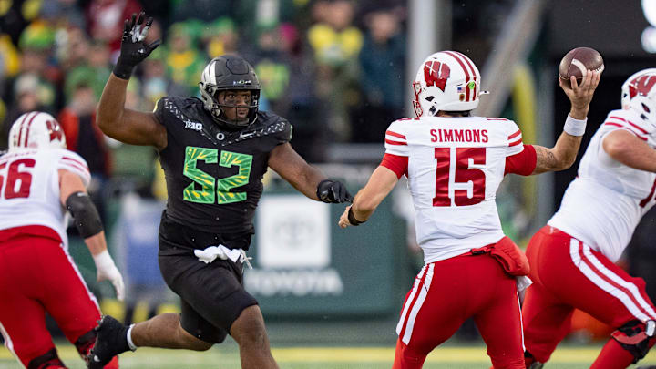 Oregon defensive lineman A'Mauri Washington, left, pressures Wisconsin quarterback Hunter Simmons as the Oregon Ducks host the Wisconsin Badgers on Oct. 25, 2025, at Autzen Stadium in Eugene, Oregon. Oregon defensive lineman A'Mauri Washington, left, pressures Wisconsin quarterback Hunter Simmons as the Oregon Ducks host the Wisconsin Badgers on Oct. 25, 2025, at Autzen Stadium in Eugene, Oregon.