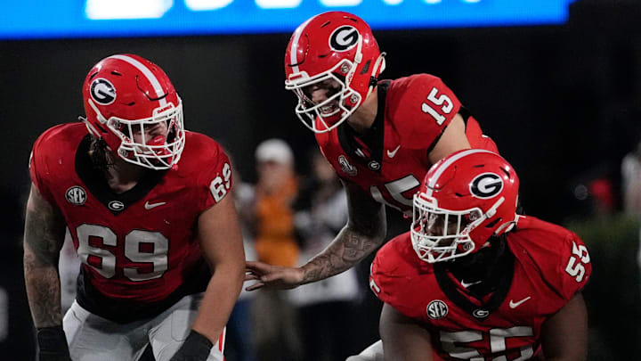 Georgia quarterback Carson Beck (15) speaks with Georgia offensive lineman Tate Ratledge (69) and Georgia offensive lineman Micah Morris (56) during the first half of a NCAA college football game against Tennessee in Athens, Ga., on Saturday, Nov. 16, 2024.