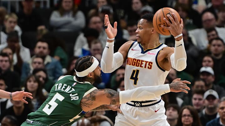 Feb 27, 2025; Milwaukee, Wisconsin, USA; Denver Nuggets guard Russell Westbrook (4) looks to pass the ball away from Milwaukee Bucks guard Gary Trent Jr. (5) in the second quarter at Fiserv Forum. Mandatory Credit: Benny Sieu-Imagn Images