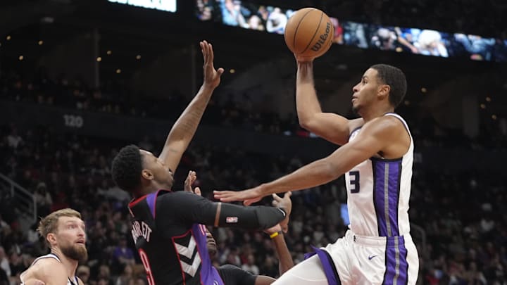 Nov 2, 2024; Toronto, Ontario, CAN; Sacramento Kings forward Keegan Murray (13) goes up to make a basket as Toronto Raptors guard RJ Barrett (9) defends during the second half at Scotiabank Arena. Mandatory Credit: John E. Sokolowski-Imagn Images