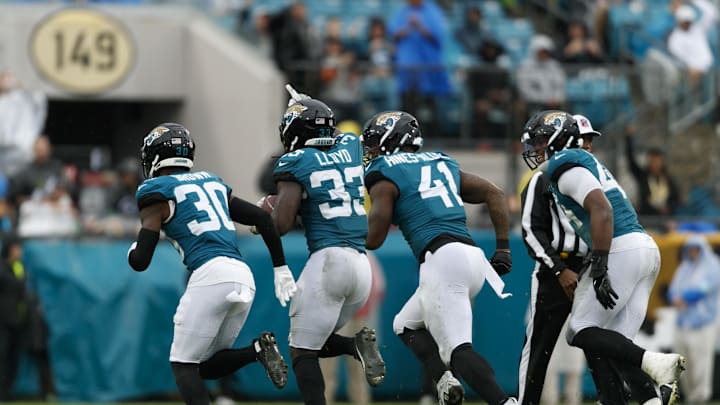 Dec 29, 2024; Jacksonville, Florida, USA; Jacksonville Jaguars linebacker Devin Lloyd (33) celebrates an interception with cornerback Montaric Brown (30), defensive end Josh Hines-Allen (41) and defensive end Travon Walker (44) against the Tennessee Titans during the second quarter at EverBank Stadium. Mandatory Credit: Morgan Tencza-Imagn Images