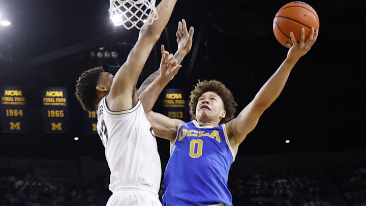 Feb 14, 2026; Ann Arbor, Michigan, USA; UCLA Bruins guard Trent Perry (0) shoots on Michigan Wolverines forward Yaxel Lendeborg (23) in the second half at Crisler Center. Mandatory Credit: Rick Osentoski-Imagn Images