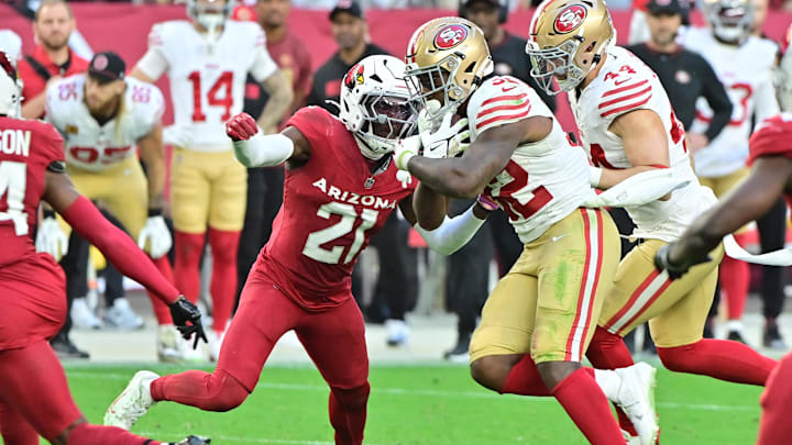 Jan 5, 2025; Glendale, Arizona, USA;  San Francisco 49ers running back Patrick Taylor Jr. (32) runs the ball as Arizona Cardinals cornerback Garrett Williams (21) defends in the second half at State Farm Stadium. Mandatory Credit: Matt Kartozian-Imagn Images