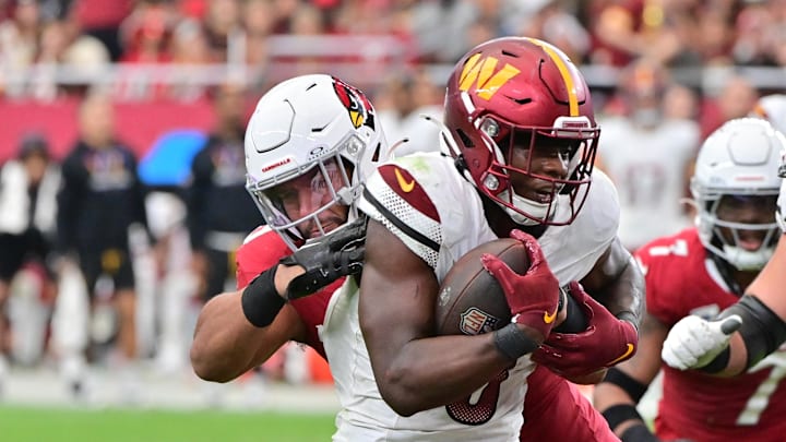 Sep 29, 2024; Glendale, Arizona, USA; Washington Commanders running back Brian Robinson Jr. (8) runs the ball as Arizona Cardinals linebacker Zaven Collins (25) defends in the second half at State Farm Stadium. Mandatory Credit: Matt Kartozian-Imagn Images Sep 29, 2024; Glendale, Arizona, USA; Washington Commanders running back Brian Robinson Jr. (8) runs the ball as Arizona Cardinals linebacker Zaven Collins (25) defends in the second half at State Farm Stadium. Mandatory Credit: Matt Kartozian-Imagn Images