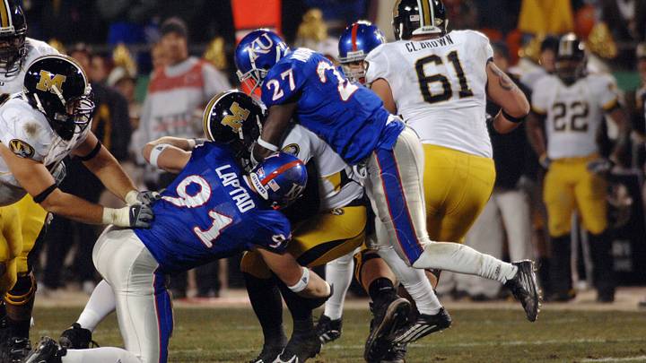 Nov 24, 2007; Kansas City, MO, USA; Missouri quarterback Chase Daniel (10) is sacked in the second quarter by Kansas safety Sadiq Muhammed and defensive end Jake Laptad (91) at Arrowhead Stadium in Kansas City, MO. Mandatory Credit: Denny Medley-USA TODAY Sports