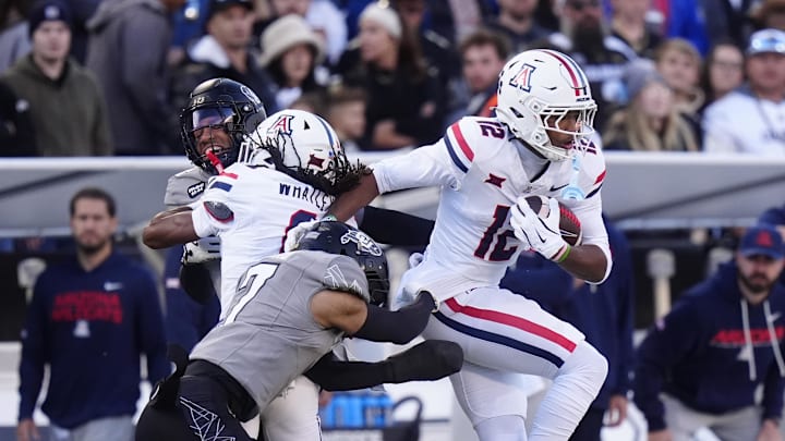 Nov 1, 2025; Boulder, Colorado, USA; Arizona Wildcats wide receiver Tre Spivey (12) runs for a touchdown past the tackle of Colorado Buffaloes defensive back Tawfiq Byard (7) in the first quarter at Folsom Field. Mandatory Credit: Ron Chenoy-Imagn Images
