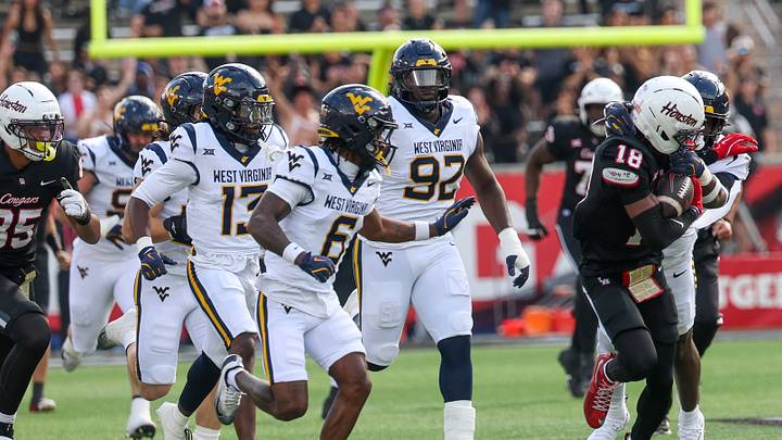 Nov 1, 2025; Houston, Texas, USA; Houston Cougars wide receiver Koby Young (18) is chased by West Virginia Mountaineers defensive back Jordan Scruggs (6) and teammates in the first half at TDECU Stadium. Mandatory Credit: Thomas Shea-Imagn Images Nov 1, 2025; Houston, Texas, USA; Houston Cougars wide receiver Koby Young (18) is chased by West Virginia Mountaineers defensive back Jordan Scruggs (6) and teammates in the first half at TDECU Stadium. Mandatory Credit: Thomas Shea-Imagn Images