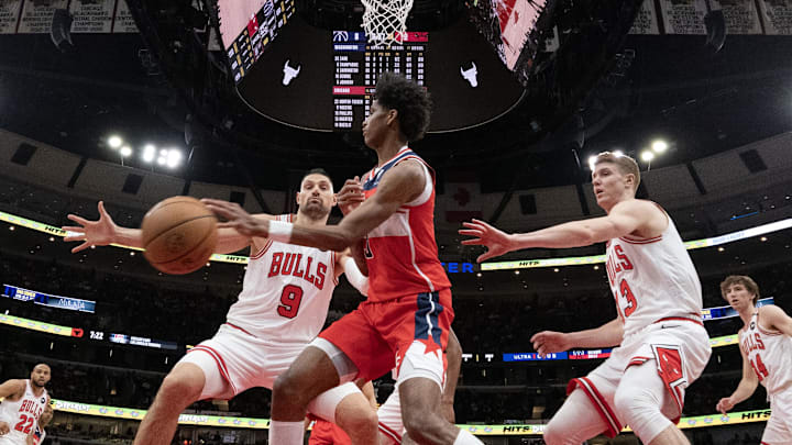 Apr 11, 2025; Chicago, Illinois, USA; Washington Wizards guard AJ Johnson (5) passed the ball around Chicago Bulls center Nikola Vucevic (9) during the first quarter at United Center. Mandatory Credit: David Banks-Imagn Images Apr 11, 2025; Chicago, Illinois, USA; Washington Wizards guard AJ Johnson (5) passed the ball around Chicago Bulls center Nikola Vucevic (9) during the first quarter at United Center. Mandatory Credit: David Banks-Imagn Images