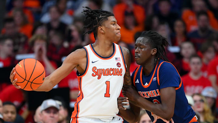 Dec 28, 2024; Syracuse, New York, USA; Syracuse Orange forward Donnie Freeman (1) controls the ball against Bucknell Bison forward Ruot Bijiek (22) during the second half at the JMA Wireless Dome. Mandatory Credit: Rich Barnes-Imagn Images