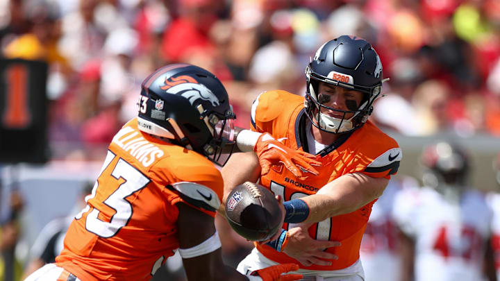 Sep 22, 2024; Tampa, Florida, USA; Denver Broncos quarterback Bo Nix (10) hands off to running back Javonte Williams (33) against the Tampa Bay Buccaneers in the first quarter at Raymond James Stadium. Mandatory Credit: Nathan Ray Seebeck-Imagn Images