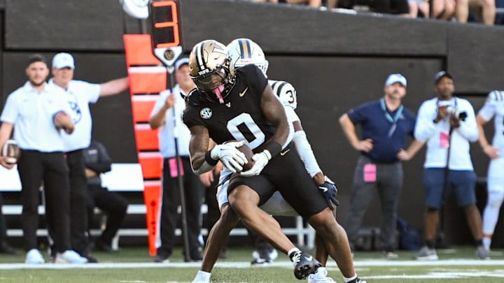 Aug 30, 2025; Nashville, Tennessee, USA;  Vanderbilt Commodores wide receiver Junior Sherril (0) drags Charleston Southern Buccaneers cornerback Jayden Hancock (30) in for a touchdown during the first half at FirstBank Stadium. Mandatory Credit: Steve Roberts-Imagn Images