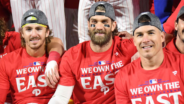 Sep 23, 2024; Philadelphia, Pennsylvania, USA; Philadelphia Phillies second base Bryson Stott (5), first baseman Bryce Harper (3) and catcher J.T. Realmuto (10) celebrate the National League East Division title after defeating the Chicago Cubs at Citizens Bank Park.
