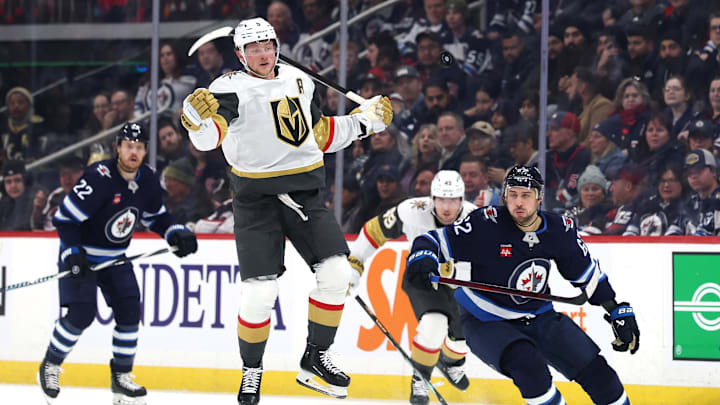 Dec 12, 2024; Winnipeg, Manitoba, CAN; Vegas Golden Knights center Jack Eichel (9) leaps past Winnipeg Jets right wing Nino Niederreiter (62) in the neutral zone in the first period at Canada Life Centre. Mandatory Credit: James Carey Lauder-Imagn Images