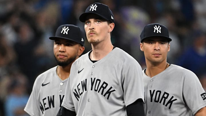 Jul 23, 2025; Toronto, Ontario, CAN;  New York Yankees starting pitcher Max Fried (54) stands between third baseman Oswald Peraza (18, left) and shortstop Anthony Volpe (11) as he waits to be relieved in the sixth inning against the Toronto Blue Jays at Rogers Centre. Mandatory Credit: Dan Hamilton-Imagn Images