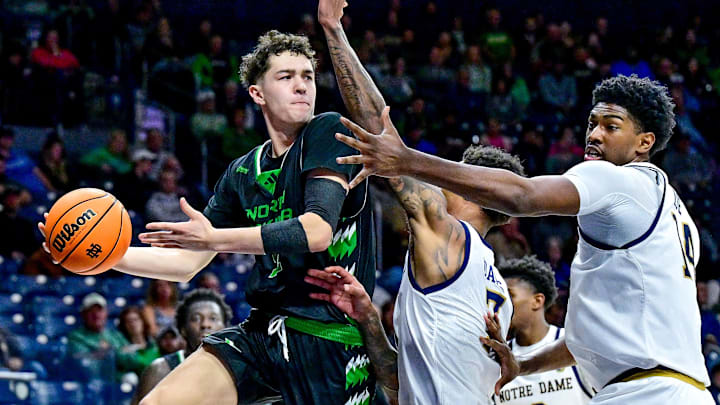 Nov 19, 2024; South Bend, Indiana, USA; North Dakota Fighting Hawks guard Treysen Eaglestaff (52) passes the ball as Notre Dame Fighting Irish forward Tae Davis (7) and forward Kebba Njie (14) defend in the second half at the Purcell Pavilion. Mandatory Credit: Matt Cashore-Imagn Images