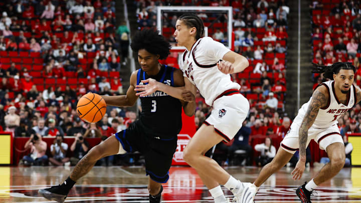 Dec 6, 2025; Raleigh, North Carolina, USA; UNC Asheville Bulldogs guard Kameron Taylor (3) dribbles with the ball against NC State Wolfpack guard Alyn Breed (7) during the second half of the game at Lenovo Center. Mandatory Credit: Jaylynn Nash-Imagn Images