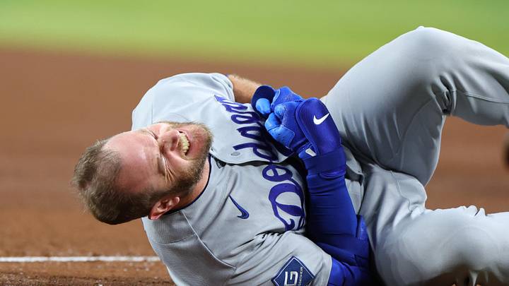 Jun 4, 2026; Phoenix, Arizona, USA; Los Angeles Dodgers third baseman Max Muncy (13) reacts with an apparent injury after colliding with Arizona Diamondbacks first baseman Ildemaro Vargas (not pictured) at first base in the fifth inning at Chase Field. Mandatory Credit: Anna Carrington-Imagn Images