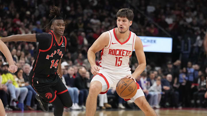 Dec 22, 2024; Toronto, Ontario, CAN; Houston Rockets guard Reed Sheppard (15) drives to the net as Toronto Raptors guard Ja'Kobe Walter (14) pursues during the second half at Scotiabank Arena. Mandatory Credit: John E. Sokolowski-Imagn Images