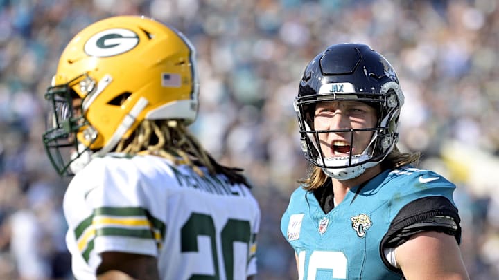 Oct 27, 2024; Jacksonville, Florida, USA; Jacksonville Jaguars quarterback Trevor Lawrence (16) speaks to Green Bay Packers safety Xavier McKinney (29) after a touchdown pass during the fourth quarter at EverBank Stadium. Mandatory Credit: Melina Myers-Imagn Images