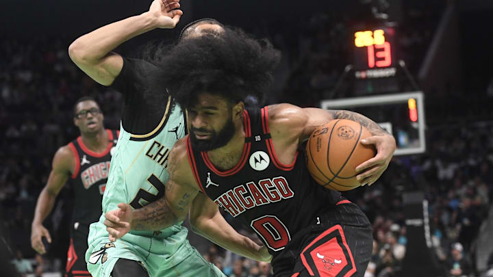 Dec 30, 2024; Charlotte, North Carolina, USA;  Chicago Bulls guard Coby White (0) drives past Charlotte Hornets guard Isaiah Wong (21) during the second half at the Spectrum Center. Mandatory Credit: Sam Sharpe-Imagn Images