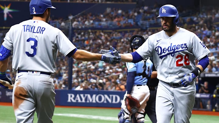 St. Petersburg, Florida, USA; Los Angeles Dodgers designated hitter J.D. Martinez (28) is congratulated by shortstop Chris Taylor (3) after he scores a run against the Tampa Bay Rays during the fifth inning at Tropicana Field in a May 2023 game. 