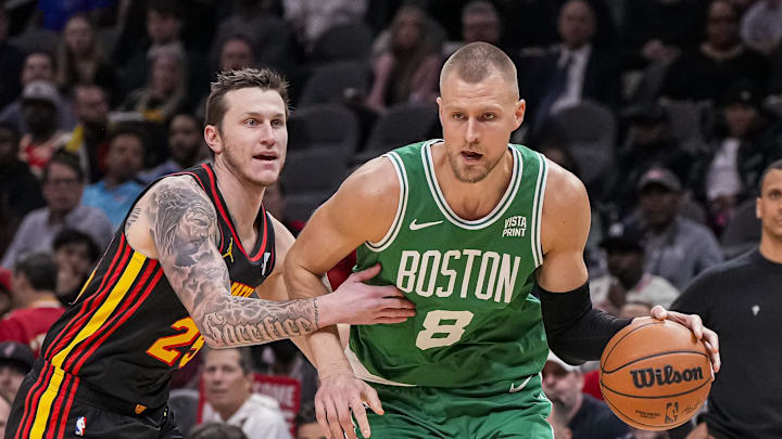 Mar 28, 2024; Atlanta, Georgia, USA; Boston Celtics center Kristaps Porzingis (8) dribbles against Atlanta Hawks guard Garrison Mathews (25) during the first half at State Farm Arena. Mandatory Credit: Dale Zanine-Imagn Images
