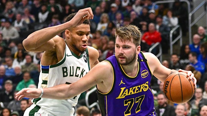 Mar 13, 2025; Milwaukee, Wisconsin, USA;  Los Angeles Lakers guard Luka Doncic (77) drives to the basket against Milwaukee Bucks forward Giannis Antetokounmpo (34) in the third quarter at Fiserv Forum. Mandatory Credit: Benny Sieu-Imagn Images