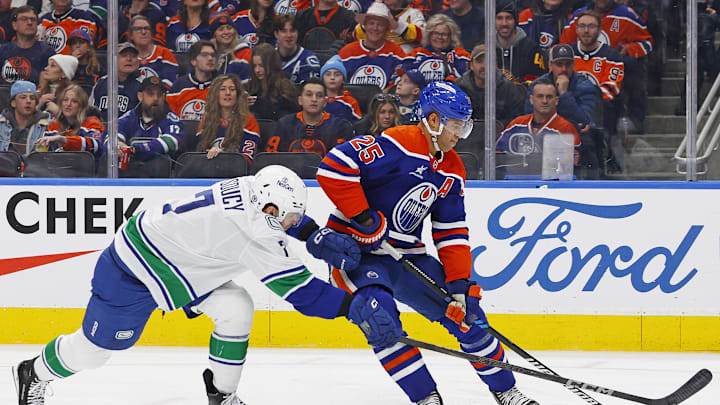 Edmonton Oilers defensemen Darnell Nurse (25) protects the puck from Vancouver Canucks defensemen Carson Soucy (7)