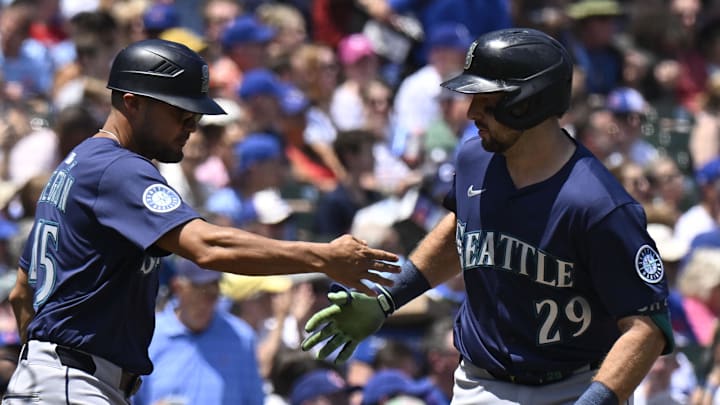 Seattle Mariners catcher Cal Raleigh (29) high fives Seattle Mariners third base coach Kristopher Negron (45)  after he hits a home run against the Chicago Cubs during the first inning at Wrigley Field on June 20. 