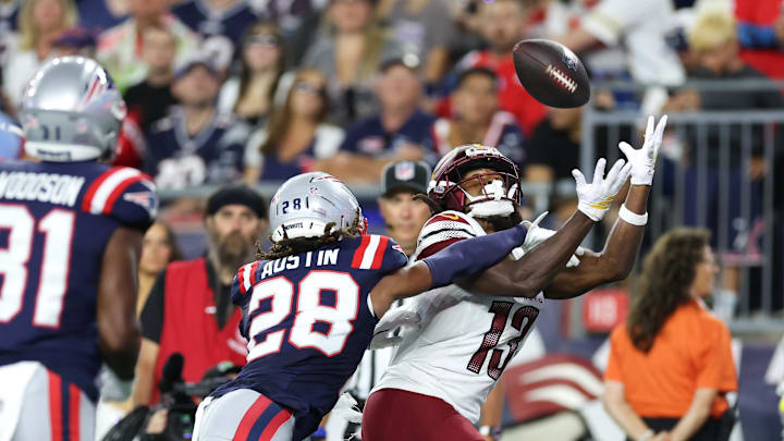 Aug 8, 2025; Foxborough, Massachusetts, USA; New England Patriots cornerback Alex Austin (28) breaks up a pass to Washington Commanders receiver KJ Osborn (13) during the first half at Gillette Stadium. Mandatory Credit: Paul Rutherford-Imagn Images
