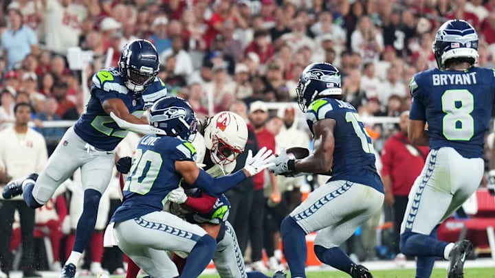 Sep 25, 2025; Glendale, Arizona, USA; Arizona Cardinals wide receiver Marvin Harrison Jr. (18) cannot make a catch against Seattle Seahawks linebacker Drake Thomas (42) as linebacker Ernest Jones IV (13) intercepts the ball in the second quarter at State Farm Stadium. Mandatory Credit: Joe Camporeale-Imagn Images