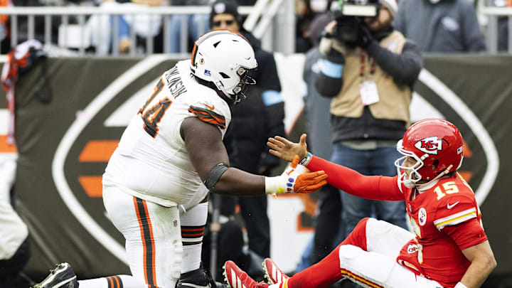 Dec 15, 2024; Cleveland, Ohio, USA; Cleveland Browns defensive tackle Dalvin Tomlinson (94) helps up Kansas City Chiefs quarterback Patrick Mahomes (15) after a tackle during the third quarter at Huntington Bank Field. Mandatory Credit: Scott Galvin-Imagn Images