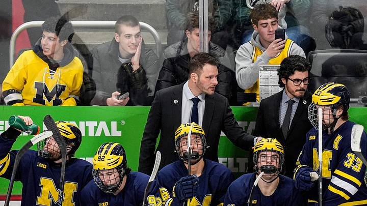 Michigan head coach Brandon Naurato, center, talks to players during the first period of Duel in the D against Michigan State at Little Caesars Arena in Detroit on Saturday, February 7, 2026. Michigan head coach Brandon Naurato, center, talks to players during the first period of Duel in the D against Michigan State at Little Caesars Arena in Detroit on Saturday, February 7, 2026.