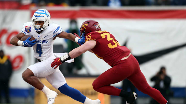 Dec 29, 2023; Memphis, TN, USA; Memphis Tigers running back Blake Watson (4) runs the ball as Iowa State Cyclones linebacker Jack Sadowsky V (33) attempts to make the tackle during the first half at Simmons Bank Liberty Stadium. Mandatory Credit: Petre Thomas-Imagn Images