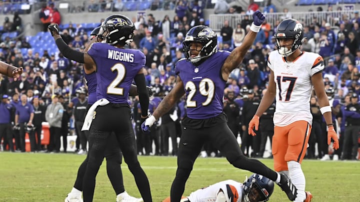Nov 3, 2024; Baltimore, Maryland, USA; Baltimore Ravens cornerback Nate Wiggins (2) and =safety Ar'Darius Washington (29) celebrate after tackling Denver Broncos wide receiver Courtland Sutton (14) on the one yard line on fourth down  the  during the  half at M&T Bank Stadium. Mandatory Credit: Tommy Gilligan-Imagn Images