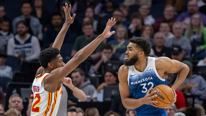 Minnesota Timberwolves center Karl-Anthony Towns (32) drives to the basket as Atlanta Hawks forward De'Andre Hunter (12) plays defense in the first half at Target Center in Minneapolis on April 12, 2024. 
