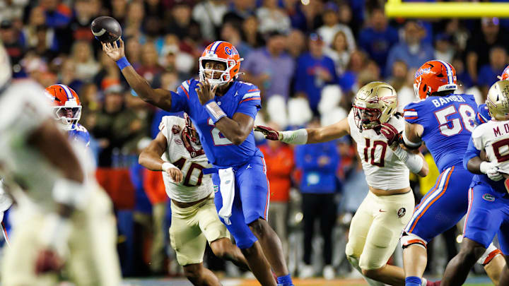 Nov 29, 2025; Gainesville, Florida, USA; Florida Gators quarterback DJ Lagway (2) throws the ball under pressure from Florida State Seminoles defensive lineman Amaree Williams (40) and Florida State Seminoles defensive lineman James Williams (10) during the first half at Ben Hill Griffin Stadium. Mandatory Credit: Matt Pendleton-Imagn Images