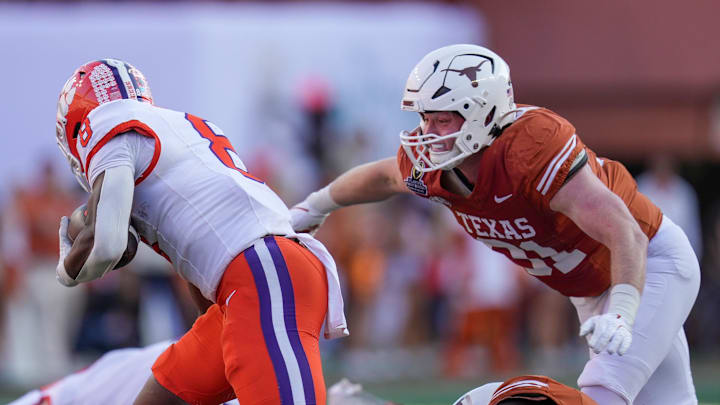 Dec 21, 2024; Austin, Texas, USA; Texas Longhorns linebacker Ethan Burke (91) tackles Clemson Tigers wide receiver Adam Randall (8) in the first half of a first round College Football Playoffs game at Darrell K Royal-Texas Memorial Stadium. Mandatory Credit: Ricardo B. Brazziell/USA Today Network via Imagn Images