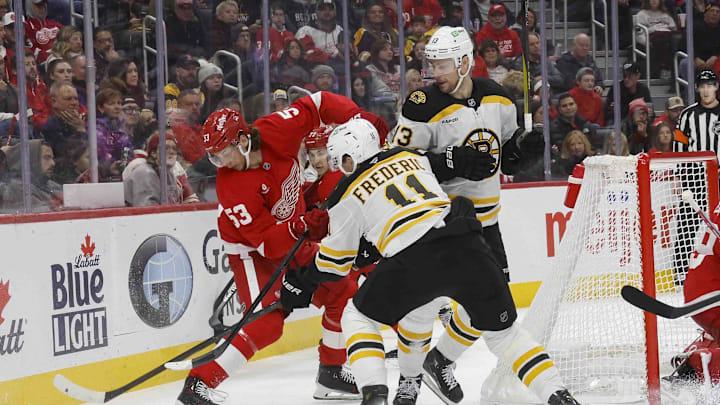 Nov 23, 2024; Detroit, Michigan, USA; Detroit Red Wings defenseman Moritz Seider (53) handles the puck against Boston Bruins center Trent Frederic (11) during the third period at Little Caesars Arena. Mandatory Credit: Brian Bradshaw Sevald-Imagn Images