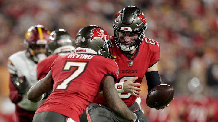 Jan 12, 2025; Tampa, Florida, USA; Tampa Bay Buccaneers quarterback Baker Mayfield (6) hands off to running back Bucky Irving (7) during the first quarter of a NFC wild card playoff against the Washington Commanders at Raymond James Stadium. Mandatory Credit: Nathan Ray Seebeck-Imagn Images Jan 12, 2025; Tampa, Florida, USA; Tampa Bay Buccaneers quarterback Baker Mayfield (6) hands off to running back Bucky Irving (7) during the first quarter of a NFC wild card playoff against the Washington Commanders at Raymond James Stadium. Mandatory Credit: Nathan Ray Seebeck-Imagn Images