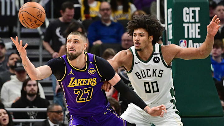 Mar 13, 2025; Milwaukee, Wisconsin, USA: Los Angeles Lakers center Alex Len (27) reaches for the ball against Milwaukee Bucks center Jericho Sims (00) in the second quarter at Fiserv Forum. Mandatory Credit: Benny Sieu-Imagn Images