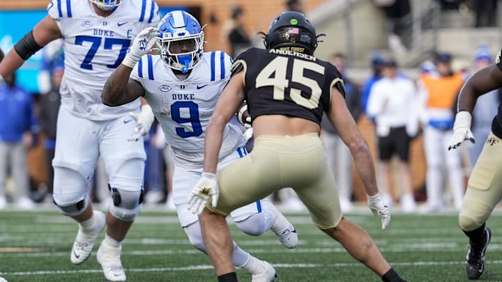 Nov 30, 2024; Winston-Salem, North Carolina, USA;  Duke Blue Devils running back Jaquez Moore (9) tries to elude Wake Forest Demon Deacons defensive back Nick Andersen (45) during the second half at Allegacy Federal Credit Union Stadium. Mandatory Credit: Jim Dedmon-Imagn Images